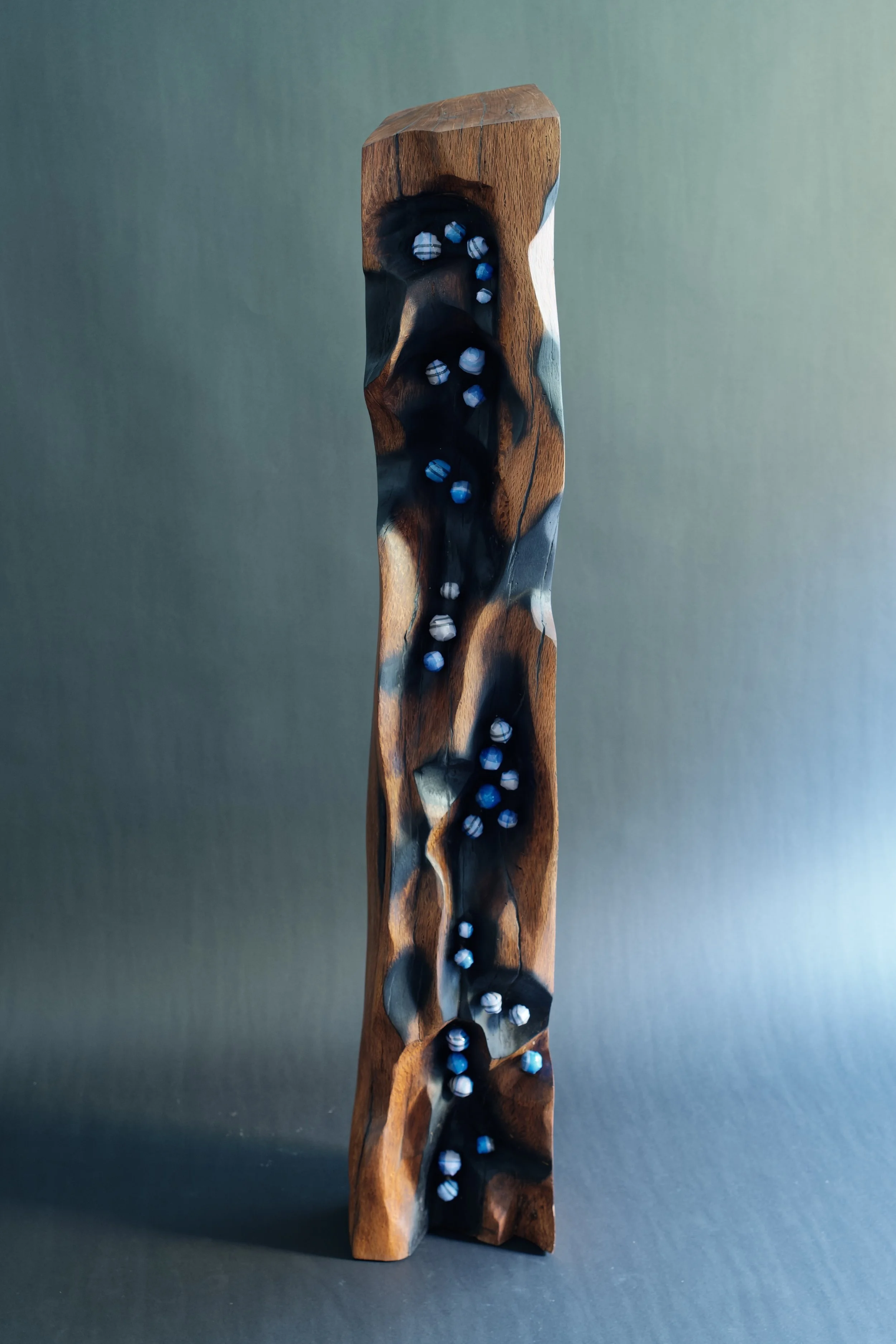 Destiny — Lines That Walked With Me — a termite-carved wooden pillar with blue-white fabric pods tracing its hollows
