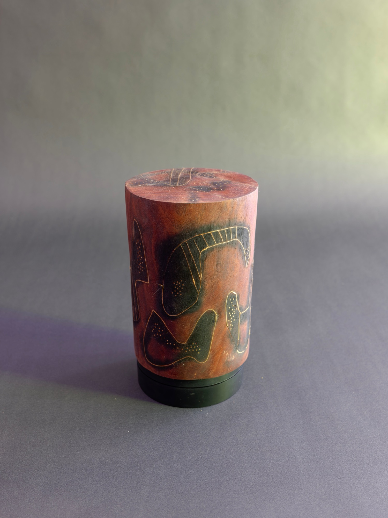 Dream — three-quarter view: incised figures wrap the rose-red face of the cylinder