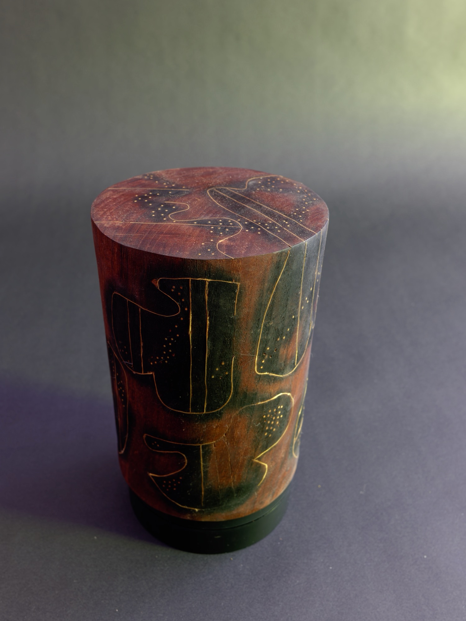 Dream — studio still, the incised figures on the warm red ground